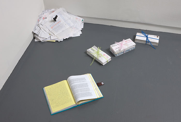 documentation photo of a handmade book, a pile of letters with a knife stabbed into it, and three bundles of letters tied with ribbon